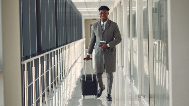 Mann mit Koffer am Flughafen – Reisen mit Diabetes
